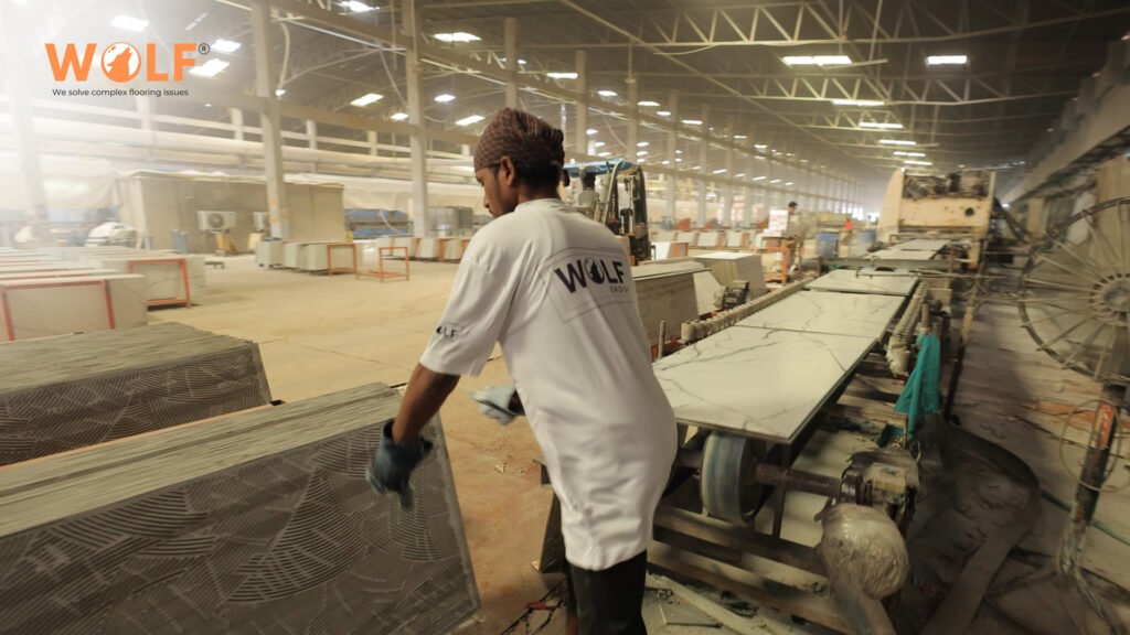 Indian factory worker handling porcelain tiles on a modern production line built for export markets.