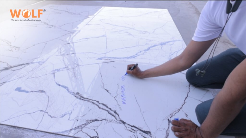 Technician marking porcelain slab during final surface inspection.