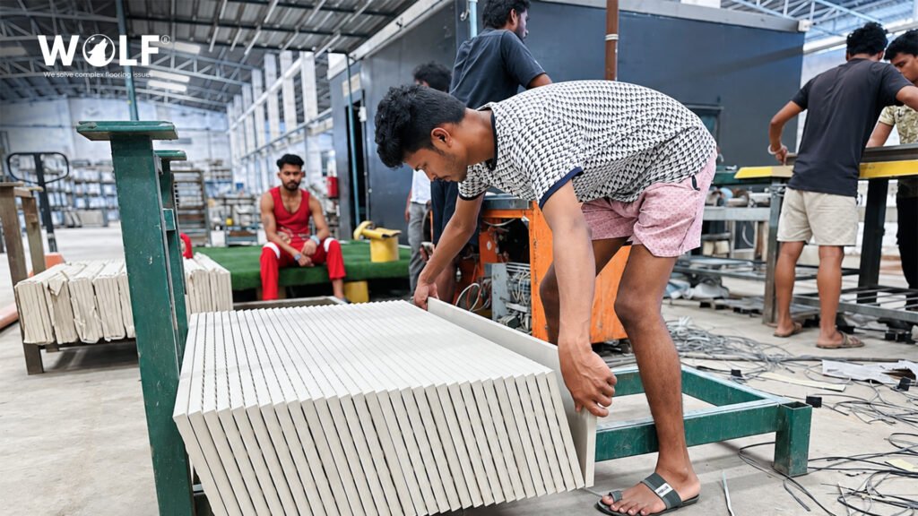 Workers at a Morbi porcelain tile manufacturer stacking finished tiles on the factory floor