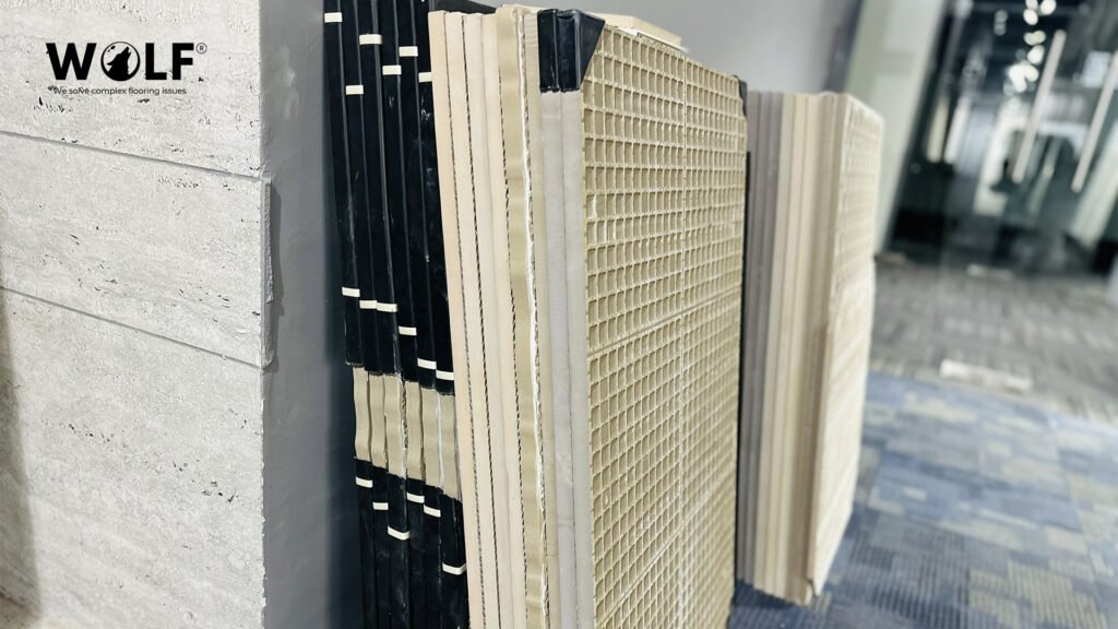 Worker checking porcelain tiles on a factory line table, with stacked tiles ready for batch-matched orders