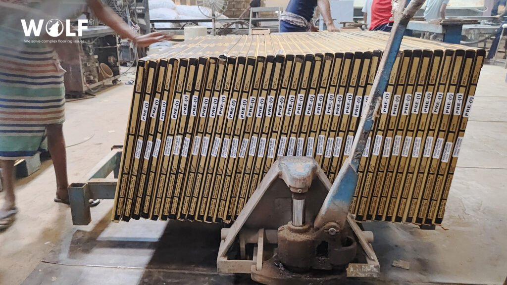 Strapped pallet of labelled porcelain tile cartons being moved with a pallet jack before container loading